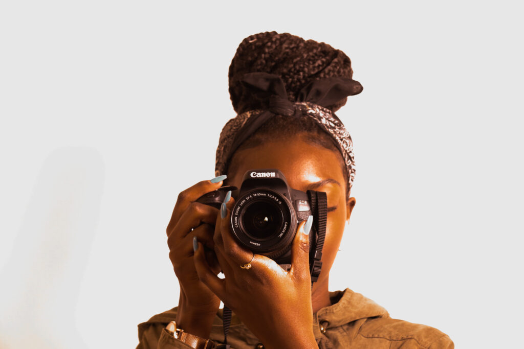 A black woman ready to take a photo from a Canon camera