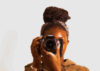 A black woman ready to take a photo from a Canon camera